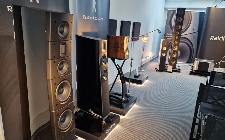 The Raidho area at the 2024 HiFi Munich show. Three speakers lined up on the left with the RD3.8 on the furthest left.