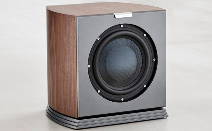 Audiovector R Sub Arreté Loudspeaker in italian walnut on a beige floor.