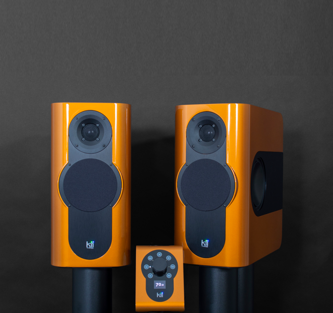 A pair of Kii Three Loudspeakers in Phoenix Orange with the Kii Controller on a black background