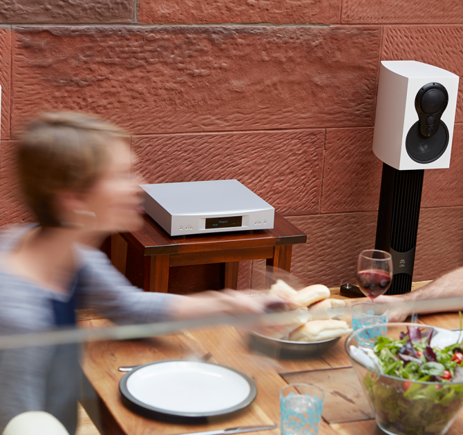Linn Akurate DSM in silver on a table beside a dinner table.
