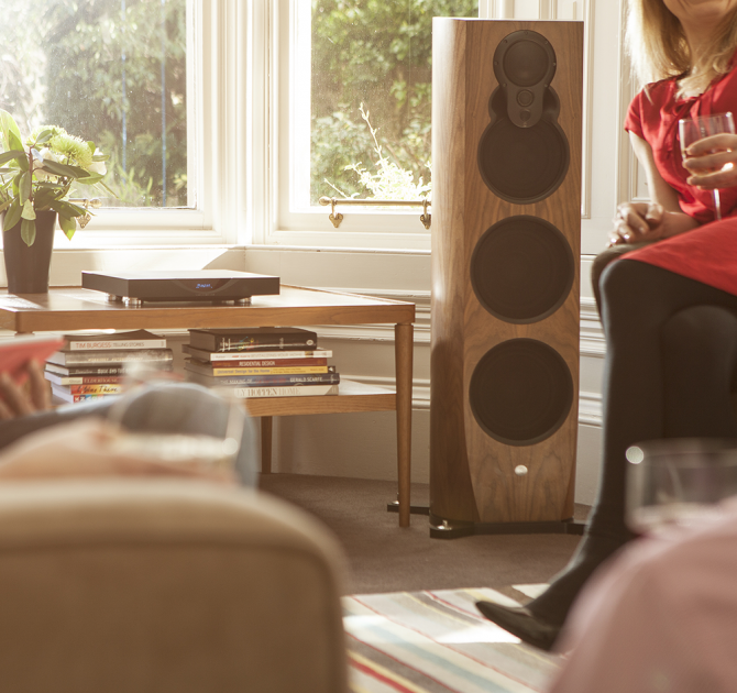Linn Klimax DSM in black on a coffee table in front of a window, next to a Linn 350 speaker.