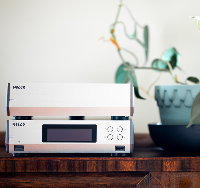 Melco N10/2 Digital Music Library in silver on a table, one on top of the other.  A plant is in a pot beside it.