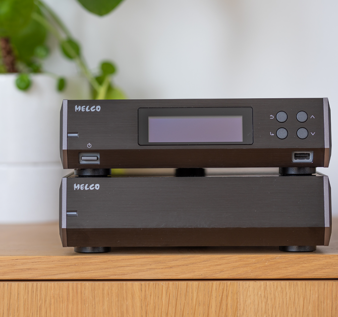 Melco N10/2 Digital Music Library in black.  One on top of the other on a sideboard with a plant beside it.