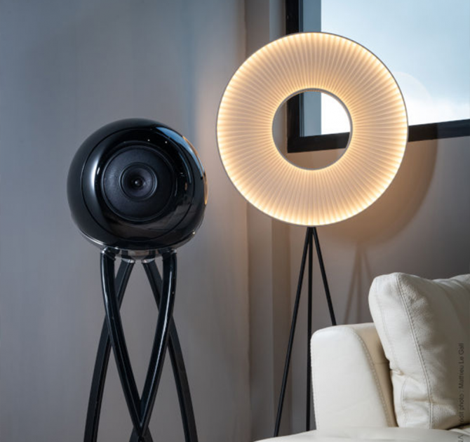 Cabasse Pearl Pelegrina Loudspeaker in black beside a circular light