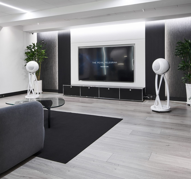 a pair of Cabasse Pearl Pelegrina Loudspeakers in white in a large living area