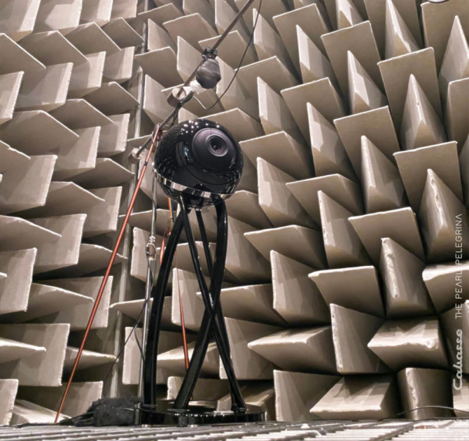 Cabasse Pearl Pelegrina Loudspeaker in black with a patterned wall behind.