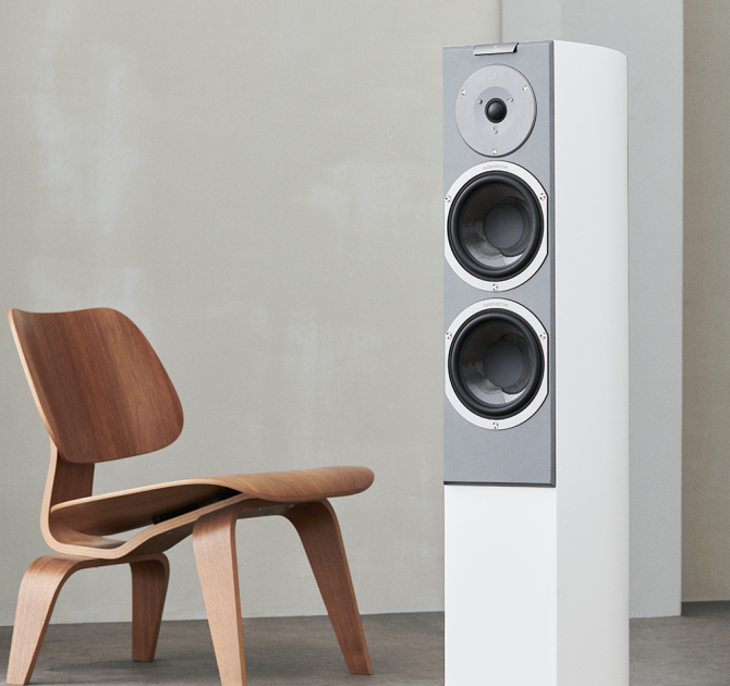 Audiovector R3 Signature in white next to a chair