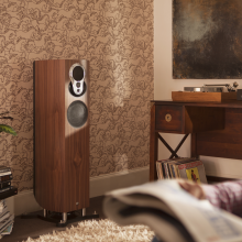 Linn Akubarik Exakt Loudspeaker in a living room against a wall with a man sitting reading the paper