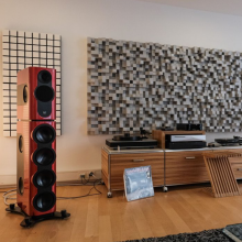 Kii Three BXT System in red in a living room setting with a side unit with two turntables.