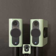 A pair of Kii Three Loudspeakers in high gloss pale green with a matching Kii Controller