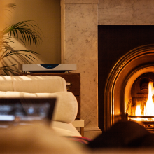 Linn Klimax DSM in silver next to a roaring living room fire.