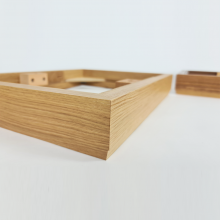 Close-up of the oak plinth with a corner of walnut visible in the background.