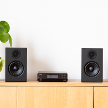 Melco N100 - HiRes Music Library - 2TB HDD, Black between two speakers