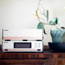 Melco N10/2 Digital Music Library in silver on a table, one on top of the other.  A plant is in a pot beside it.