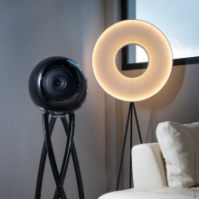 Cabasse Pearl Pelegrina Loudspeaker in black beside a circular light