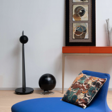 Cabasse Pearl SUB Loudspeaker in a living room with a blue chair in the foreground