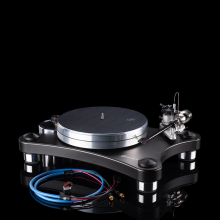 VPI Prime 21 Plus Turntable in black with a coiled wire in front of it.  On a black background.  Standing on a reflective surface.