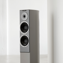 The top section of a tall, slim speaker in a grey colour