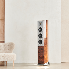 Audiovector R8 Arreté Loudspeaker in Italian Walnut Burl beside a cream sofa