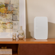 SONOS Five in white on a cabinet beside a vase