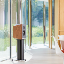 A single Titan 505 speaker on a stand with the grill off in front of large glass doors.