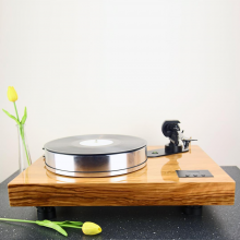 Project Xtension 12 (no cartridge) on a work surface with one yellow tulip in a vase and one laying in front of the turntable.